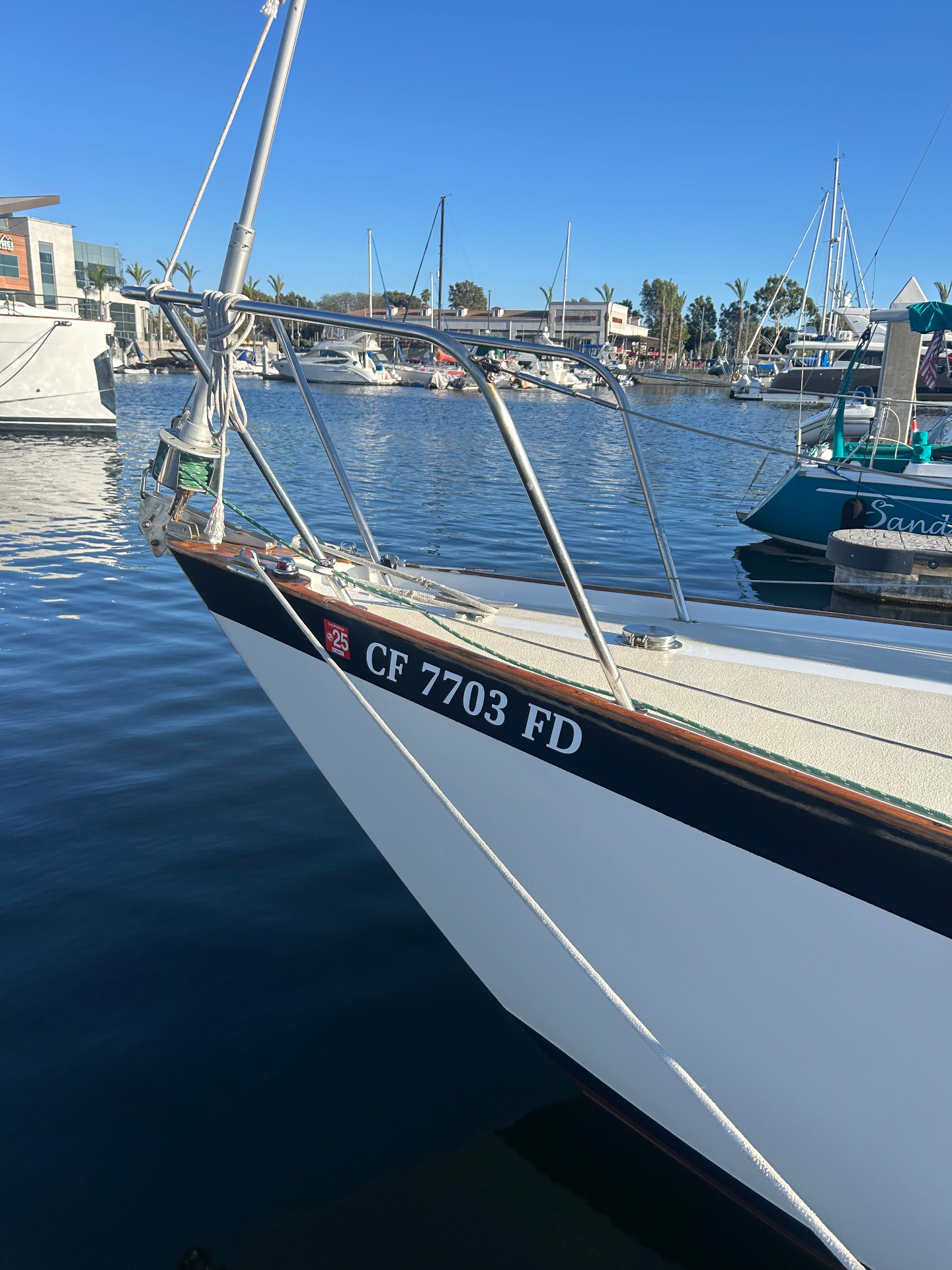 California CF 7703 FD registration numbers on a sailboat bow at the marina